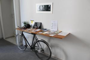 那不勒斯N'Art Suites - Napoli的一辆自行车停在墙上,旁边配有桌子