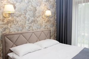 帕兰加Villa Airina的卧室配有一张床,墙上挂着两盏灯