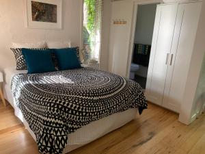 墨尔本Garden Cottage St Kilda的一间卧室配有一张带黑白色棉被的床