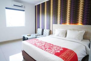美娜多万鸦老梅尔斯宾馆的一间卧室设有一张大床和一个窗户。
