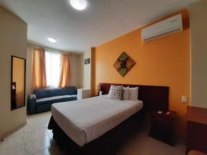 瓜亚基尔天空套房酒店的酒店客房,配有床和沙发