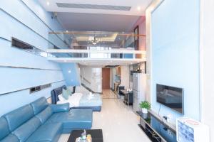 广州广州茶阳国际酒店公寓（北京路金润铂宫店）的客厅配有蓝色的沙发和电视