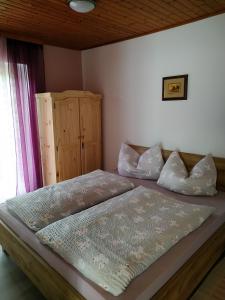 KirchbachApartmenthaus Kestel的一间卧室配有一张床和一个木制橱柜