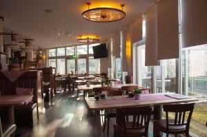 皮特林根多米泽尔阿尔特波斯特酒店的餐厅设有木桌、椅子和窗户。