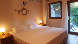契拉勒蒙特别墅酒店的一间卧室配有一张带两盏灯的床和一扇窗户。