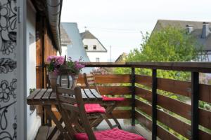 HasselbachFerienwohnung Stein mit Sauna的阳台配有两把椅子和一张鲜花桌子