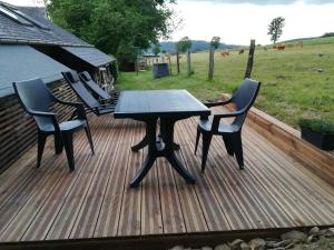 特鲁瓦蓬Le Fournil Gîte Rural的木制甲板上配有桌椅