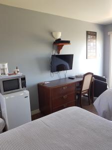 卡穆拉斯卡海军陆战队汽车旅馆的一间卧室配有一张桌子、一台电脑和一张床
