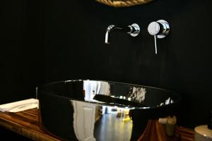 伊兹拉水润酒店的黑色浴室设有浴缸和水槽