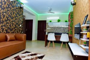 特里凡得琅Green Royale Living Spaces - Luxury Serviced Apartments的客厅配有沙发和两把白色椅子
