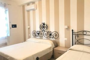 特罗佩阿Appartamento VistaMare的一间卧室设有两张床和条纹墙
