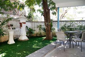 曼谷Rubin Home的花园配有桌椅和一棵树