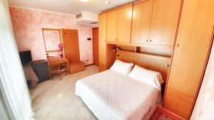 利尼亚诺萨比亚多罗弗拉伊皮尼酒店及健康中心的一间小卧室,配有白色的床和一张书桌