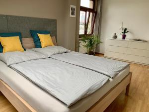 莱比锡Charmante Dachgeschoss Wohnung的一间卧室配有一张大床,提供黄色和蓝色的枕头