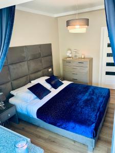 波别罗沃Apartamenty Silence Baltic Indygo的一间卧室配有一张带蓝色毯子的大床
