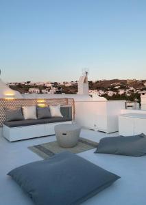 米克诺斯城Villa Loom Mykonos Town的带沙发的屋顶露台,享有城市美景
