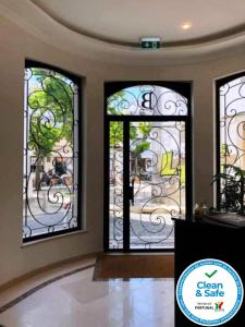 拉戈斯Bowen, Luxury Suites的一间房子里设有三扇彩色玻璃窗的房间