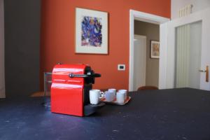 摩德纳La casa in via della Torre的一张带杯子的桌子上的红色咖啡机
