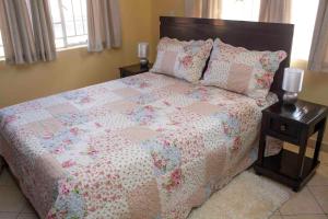 利隆圭Chrinas Guest House的一间卧室配有一张带被子和枕头的床
