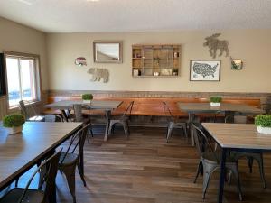 奇斯顿Rockerville Lodge & Cabins的一间在房间内配有桌椅的餐厅
