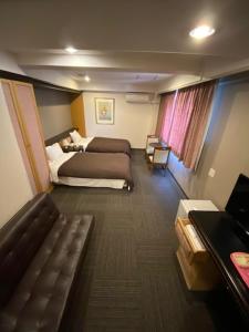 泉佐野丰荣酒店的酒店客房,配有床和沙发