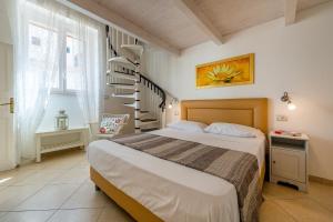 滨海波利尼亚诺Dimora Grottone的一间卧室设有一张床和一个螺旋楼梯