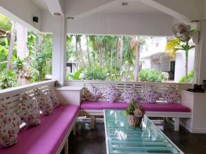 涛岛涛岛泰安度假酒店的门廊配有紫色和粉红色枕头和玻璃桌