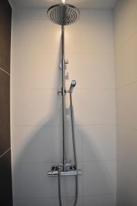 那慕尔La Mosane的浴室铺有白色瓷砖,设有淋浴。