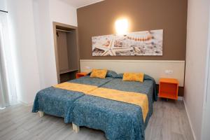 埃尔阿雷纳尔Apartamentos Arcadio的一间卧室配有一张带蓝色棉被和橙色桌子的床。