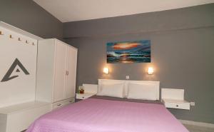 阿尔卡萨阿尔法一室公寓的一间卧室配有一张带紫色毯子的床