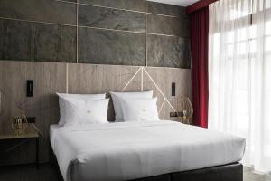 扎科帕内Nosalowy Park Hotel & Spa的卧室配有一张带红色窗帘的大型白色床