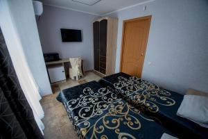鄂木斯克Hotel Zolotoi Lev的一间卧室配有一张带黑色和金色毯子的床。