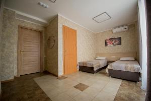 鄂木斯克Hotel Zolotoi Lev的一间卧室设有两张床,卧室内有一扇门