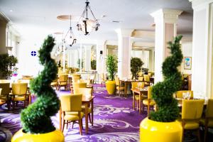 卡迪夫The Angel Hotel的一间设有黄色椅子和桌椅的餐厅