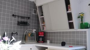 格兰纳Pinglans bakficka的一个带水槽和白色橱柜的厨房
