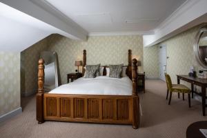 伊夫舍姆伍德诺顿酒店的一间卧室配有一张床、一张书桌和一面镜子