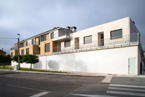 索托德拉马里纳Apartamentos Salitre的白色的建筑,旁边设有阳台