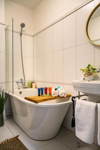 文茨皮尔斯Villa Louis的白色的浴室设有浴缸和水槽。