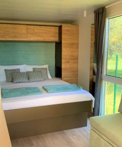 帕科坦Camp Vransko lake - Mobile homes的一间卧室配有一张大床和木制床头板