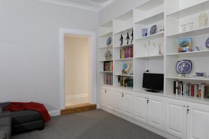 塔姆沃思Rawson's Retreat - Five Bedroom Home - Walk CBD - Includes Breakfast的客厅配有白色的架子和电视