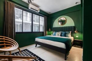 曼谷The Mellow at Silom的绿色卧室配有床和镜子