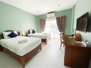 呵叻库拉纳瑞庭院精品酒店的酒店客房配有两张床、一张书桌和一张书桌。