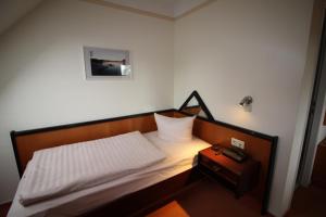 普劳西瑞克酒店的一间小卧室,配有床和床头柜