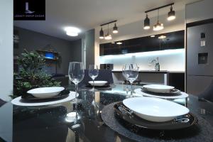 扎达尔Legacy Marine2 - Zadar, Luxury Suites的餐桌,配有酒杯和盘子