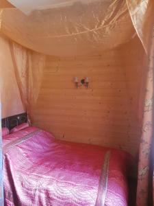 Bonneuil-en-ValoisEn pleine nature的一间小卧室,在帐篷里配有一张床
