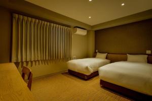 京都ikoi HOTEL的酒店客房设有两张床和窗户。
