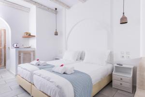 圣安娜纳克索斯Cycladic Islands Hotel & Spa的白色卧室 - 带两张床和毛巾