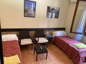 佩罗圣莫尼卡住宿加早餐旅馆的一间设有两张床和一张桌子及椅子的房间