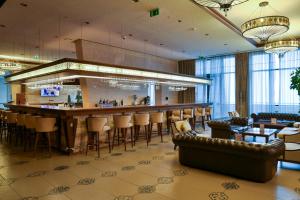 沙达格Shahdag Hotel & Spa的酒店大堂的酒吧,配有椅子和柜台
