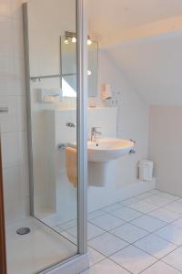 Ebergötzen优特酒店的一间带玻璃淋浴和水槽的浴室